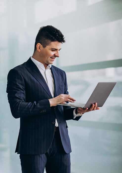 Young handsome business man with laptop in office